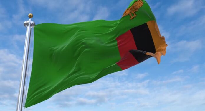 Zambia flag with flagpole waving in rolling clouds looping, 4K Perfect Loop